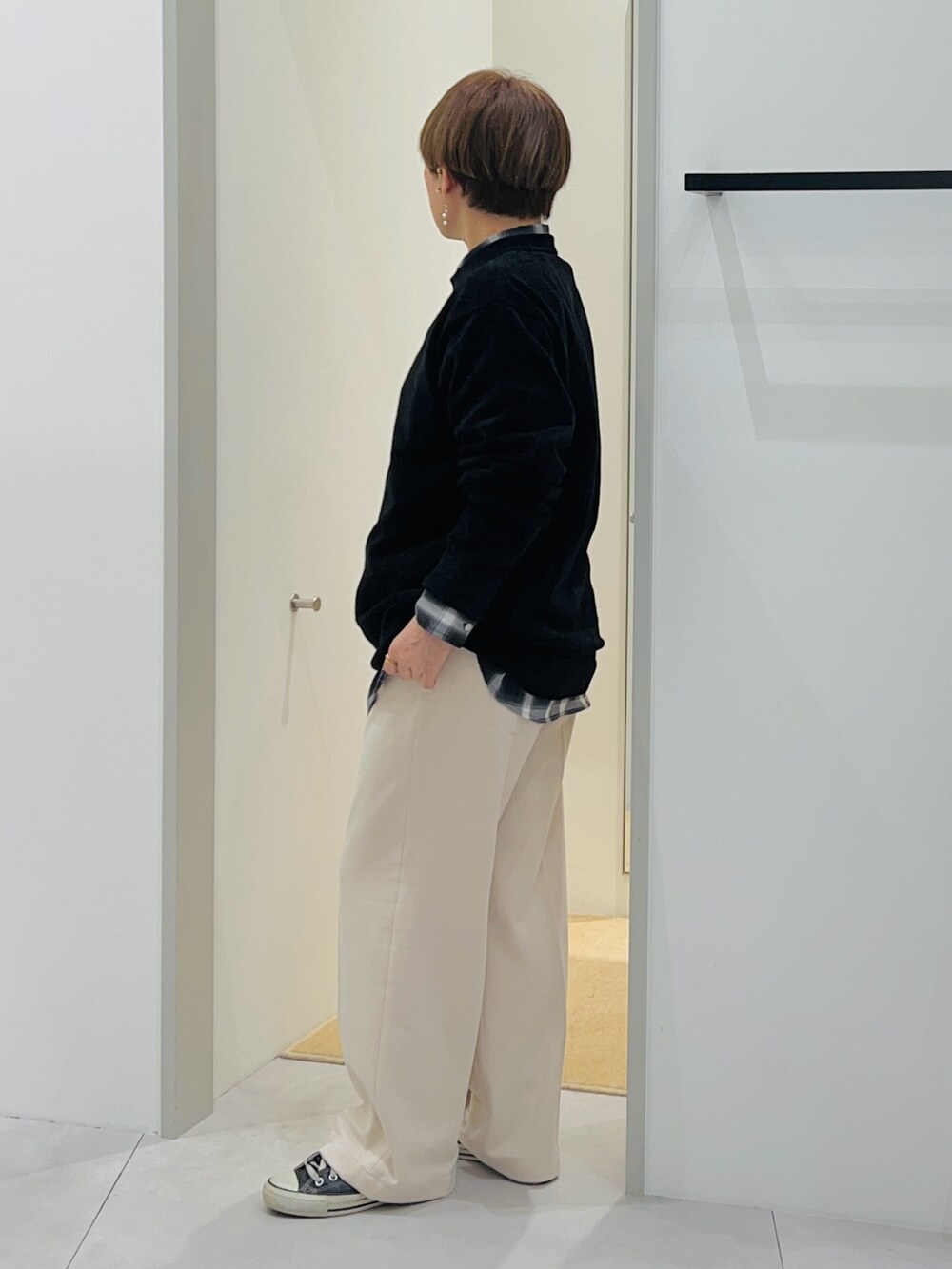 ブラック系のシャツ/ブラウス、ブラック系のニット/セーター、ホワイト系のその他パンツを着用したレディースの秋コーディネートの2枚目の写真