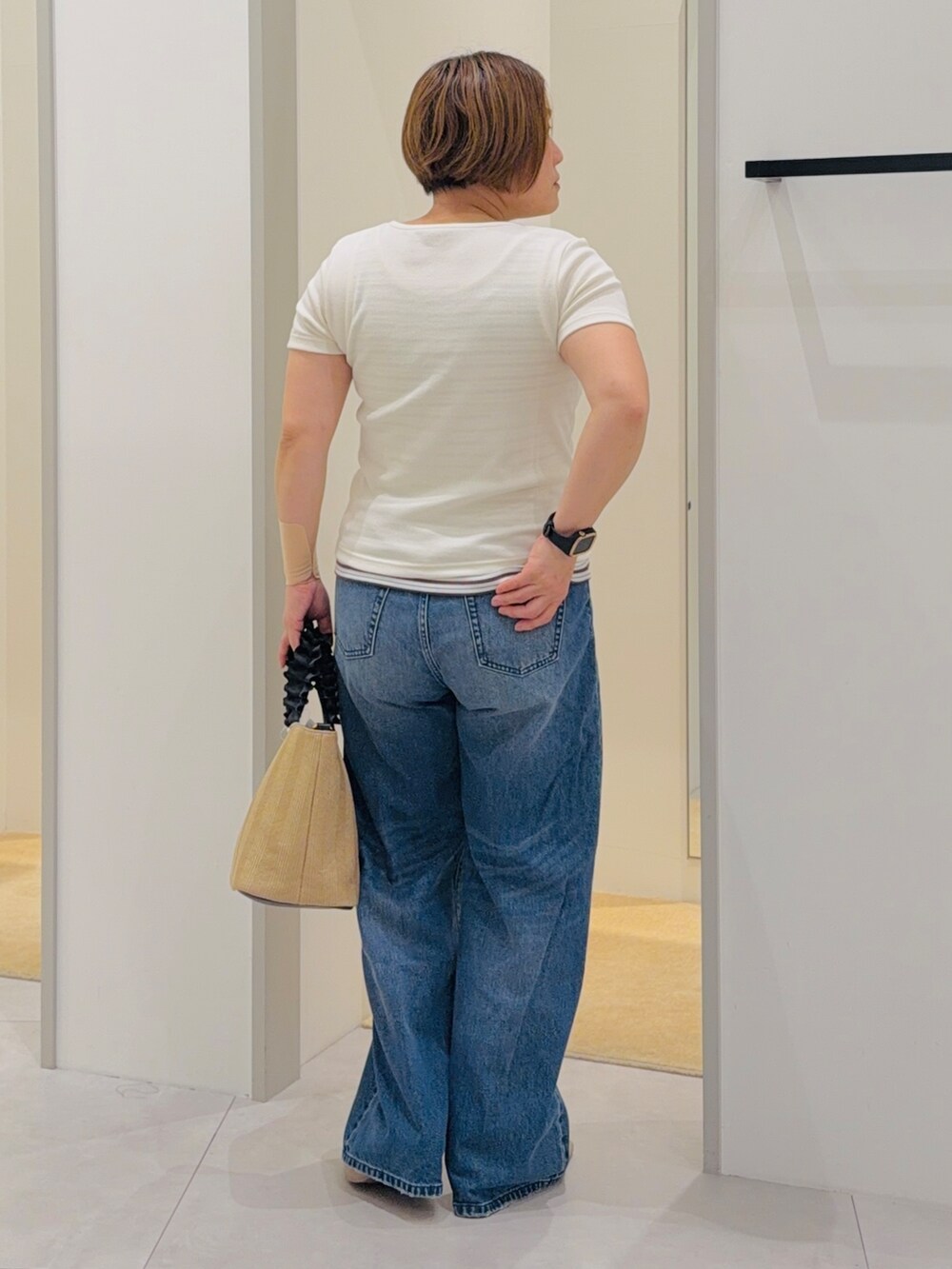 ホワイト系のTシャツ/カットソー、ベージュ系のタンクトップ、ブルー系のデニムパンツを着用したレディースの夏コーディネートの4枚目の写真