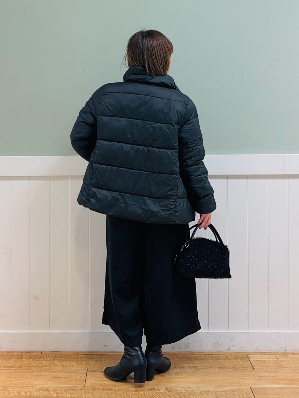 ブラック系のその他アウター、ホワイト系のニット/セーター、ブラック系のその他パンツを着用したレディースの冬コーディネートの6枚目の写真