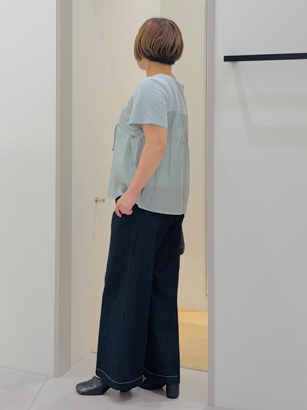 グリーン系のTシャツ/カットソー、ブラック系のデニムパンツ、グリーン系のショルダーバッグを着用したレディースの夏コーディネートの3枚目の写真