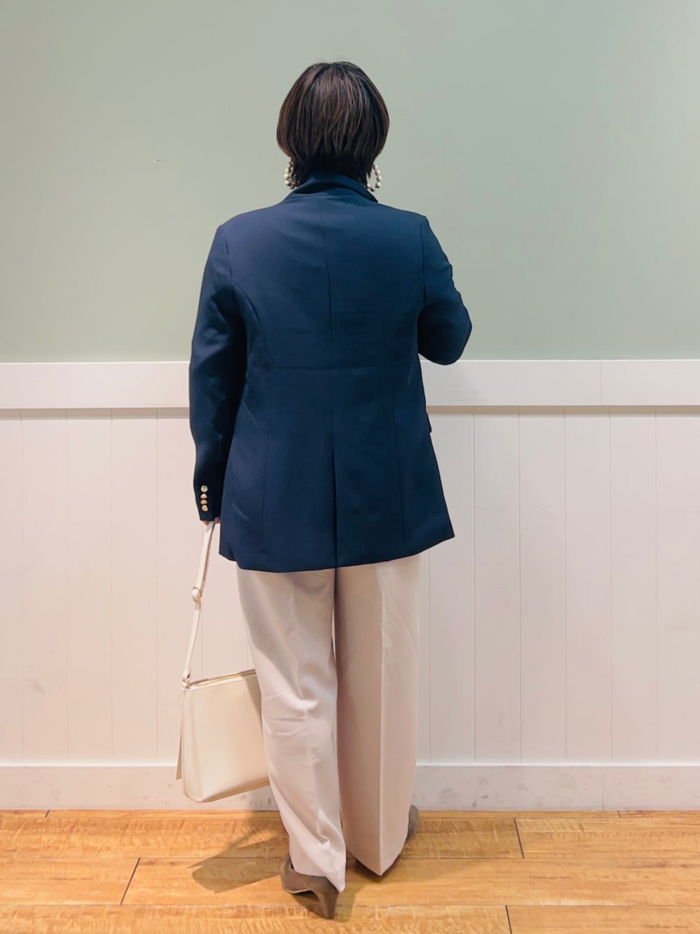 ピンク系のニット/セーター、ブルー系のテーラードジャケット、ベージュ系のその他パンツを着用したレディースの冬コーディネートの2枚目の写真