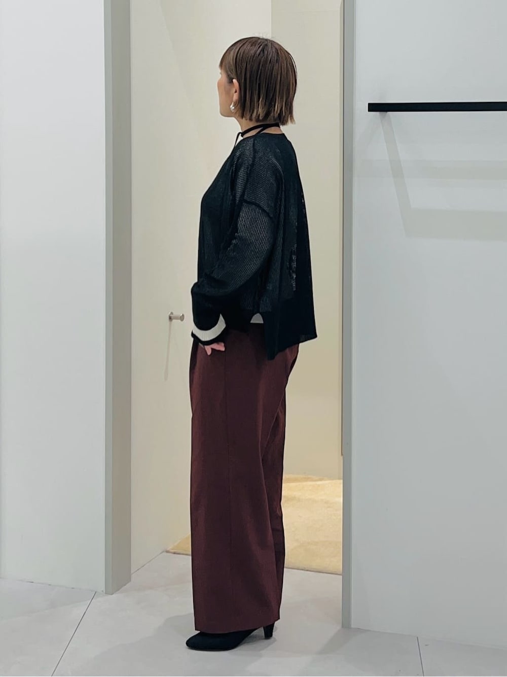 ブラック系のニット/セーター、ホワイト系のニット/セーター、ブラウン系のその他パンツを着用したレディースの春コーディネートの2枚目の写真