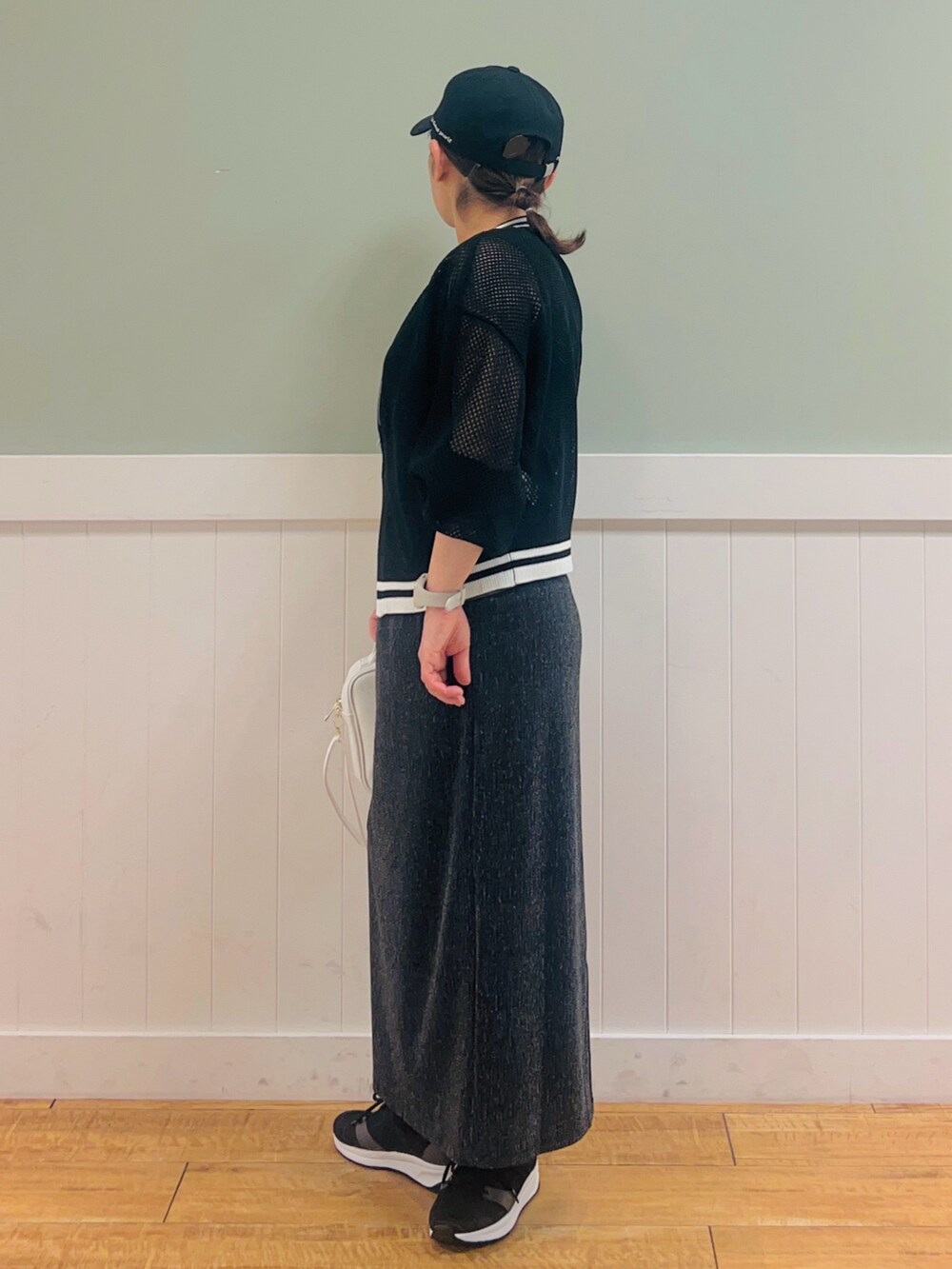 ブラック系のカーディガン/ボレロ、ホワイト系のショルダーバッグ、グレー系のタンクトップを着用したレディースの春コーディネートの2枚目の写真