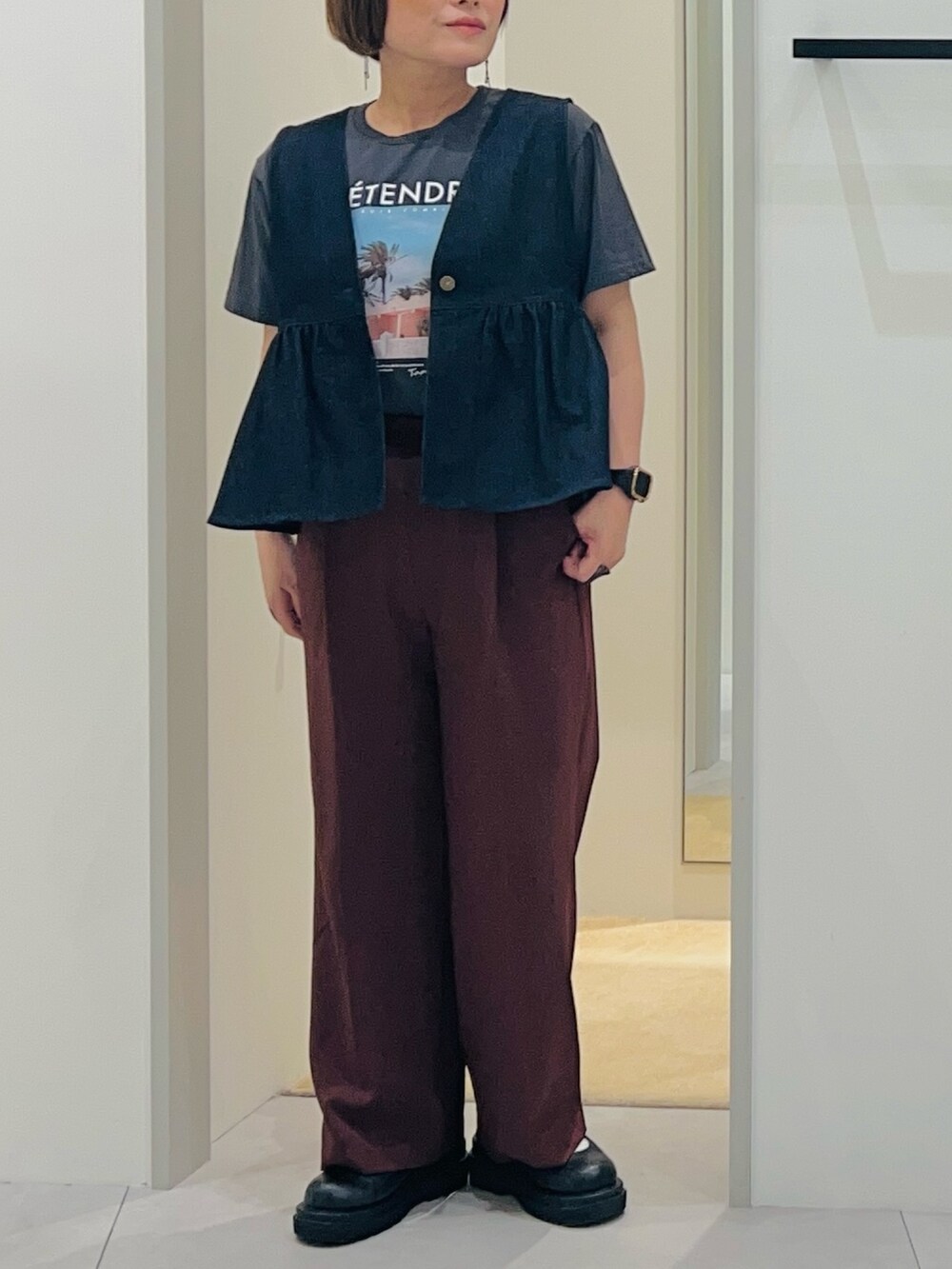 ブルー系のベスト、ブラック系のパンプス、ブラウン系のその他パンツを着用したレディースの春コーディネートの5枚目の写真