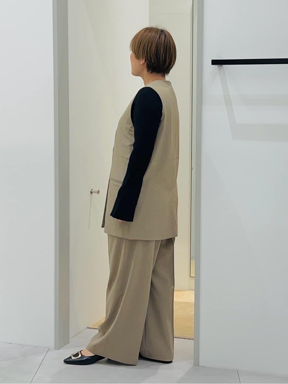ベージュ系のベスト、ブラック系のニット/セーター、ベージュ系のその他パンツを着用したレディースの冬コーディネートの3枚目の写真