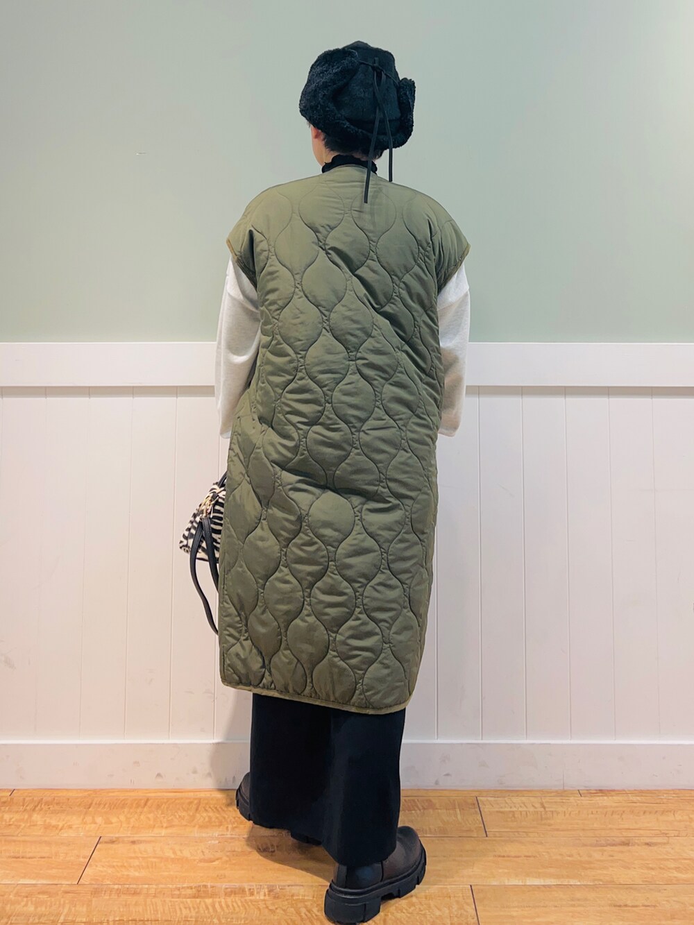 グリーン系のノーカラーコート、グレー系のスウェット、ブラック系のショルダーバッグを着用したレディースの秋コーディネートの2枚目の写真