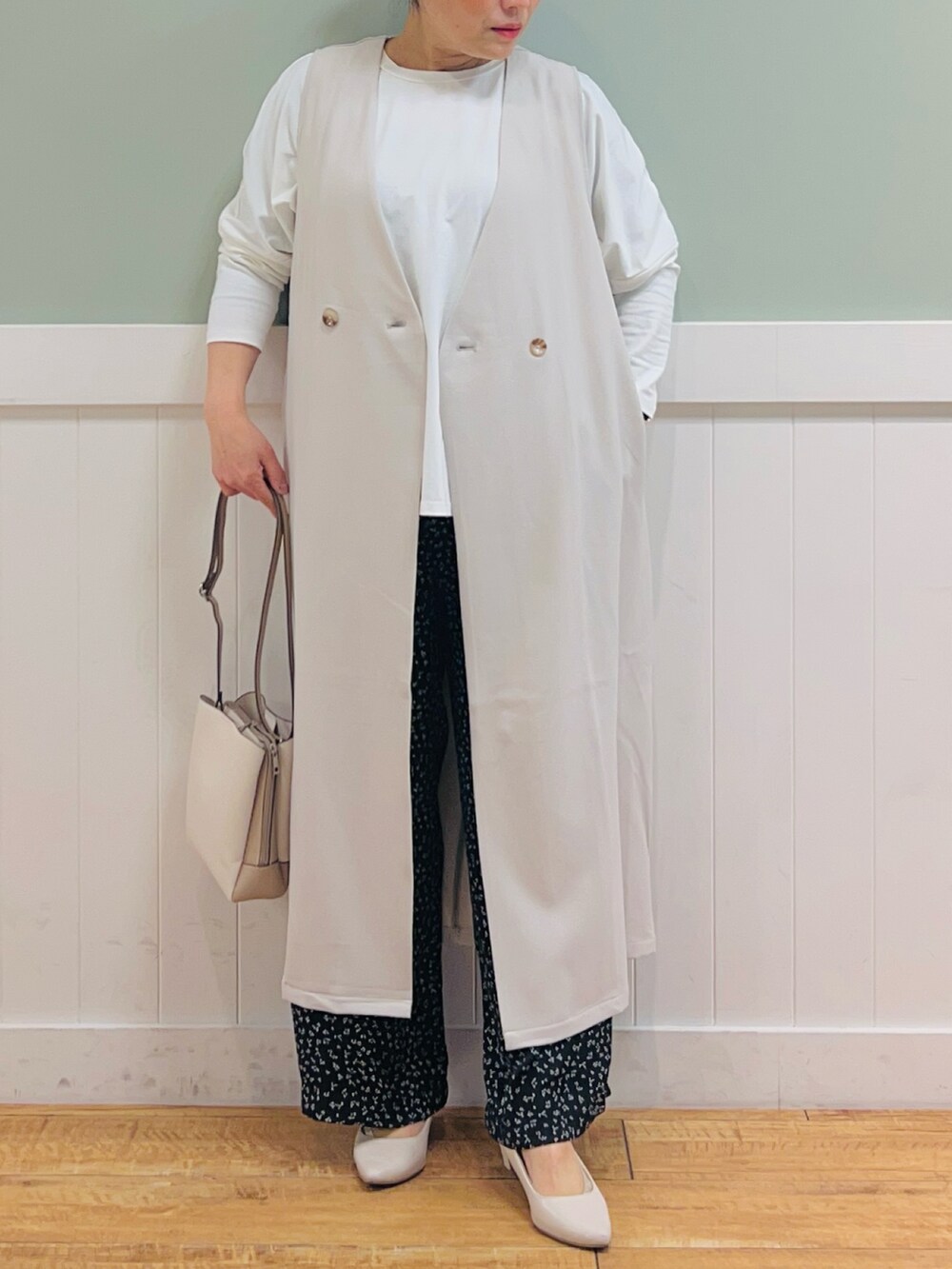 ベージュ系のベスト、ホワイト系のTシャツ/カットソー、ベージュ系のショルダーバッグを着用したレディースの春コーディネートの4枚目の写真