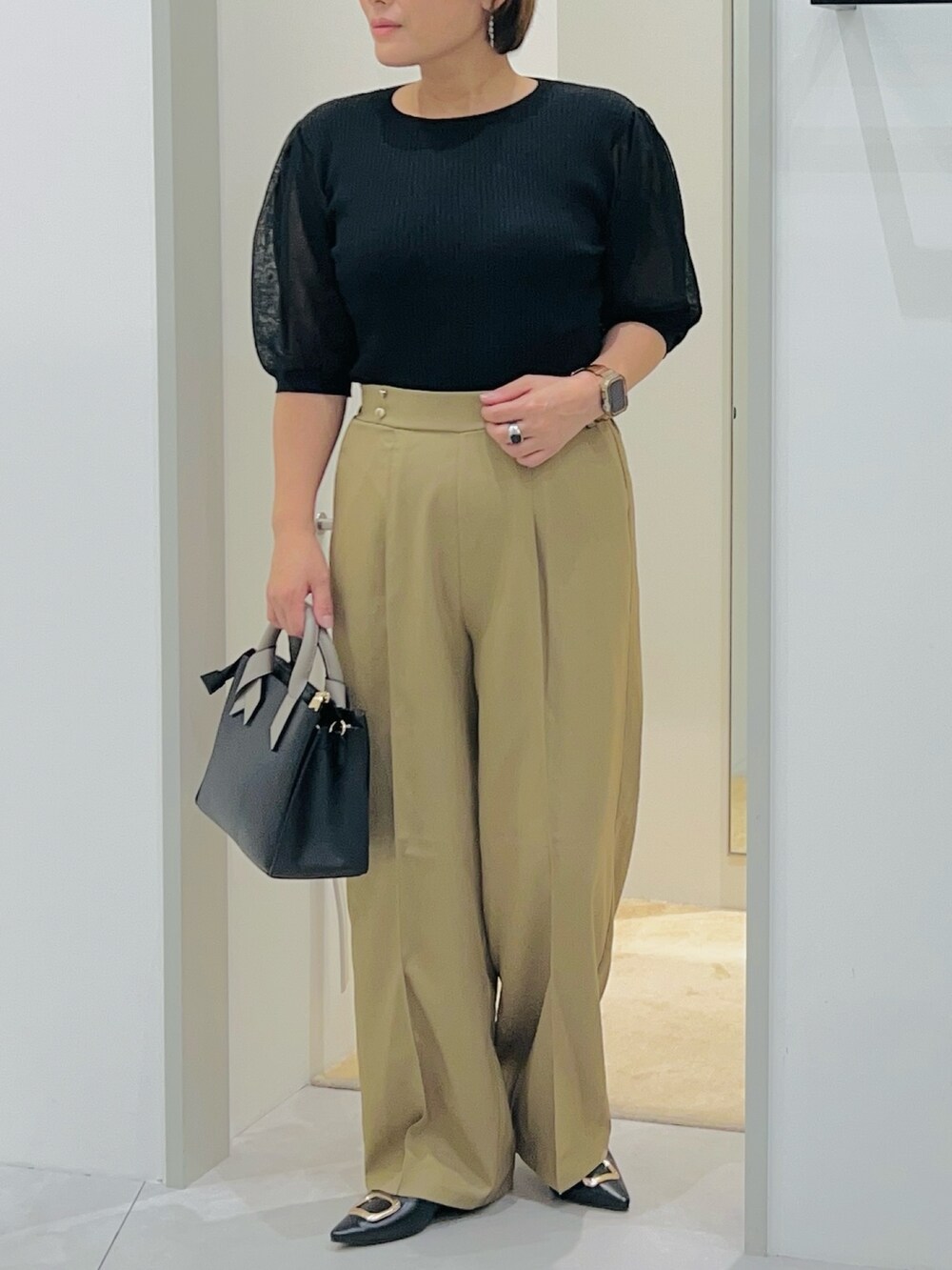 ブラック系のニット/セーター、ベージュ系のその他パンツ、ブラック系のショルダーバッグを着用したレディースの秋コーディネートの5枚目の写真