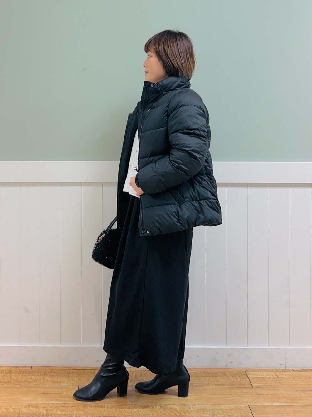 ブラック系のその他アウター、ホワイト系のニット/セーター、ブラック系のその他パンツを着用したレディースの冬コーディネートの5枚目の写真