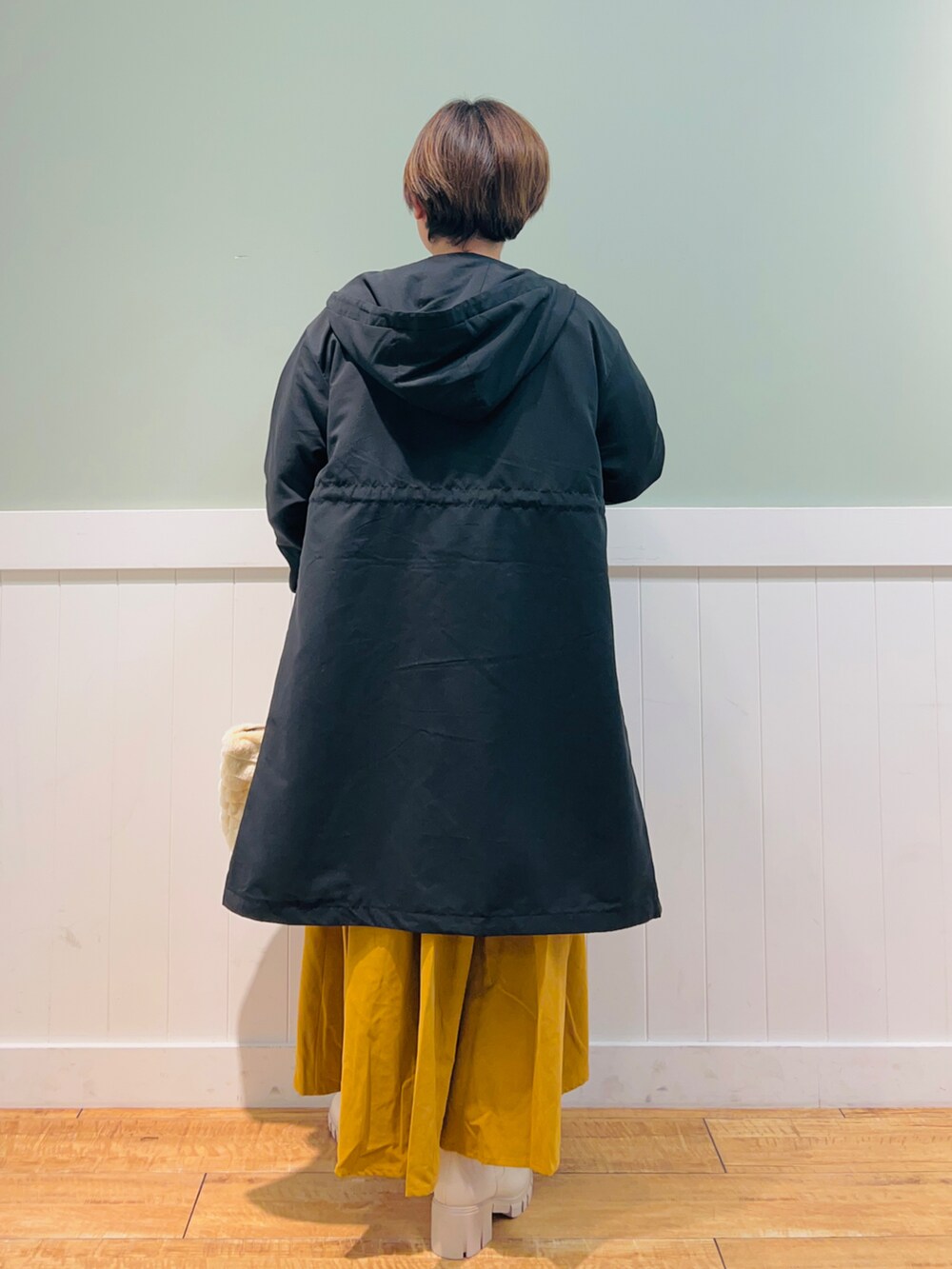 ブラック系のニット/セーター、ブラック系のその他アウター、ベージュ系のトートバッグを着用したレディースの冬コーディネートの3枚目の写真