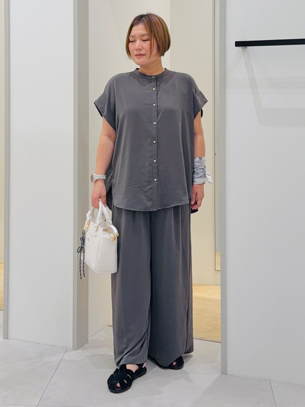 ブラック系のシャツ/ブラウス、ブラック系のその他パンツ、ホワイト系のトートバッグを着用したレディースの夏コーディネートの2枚目の写真