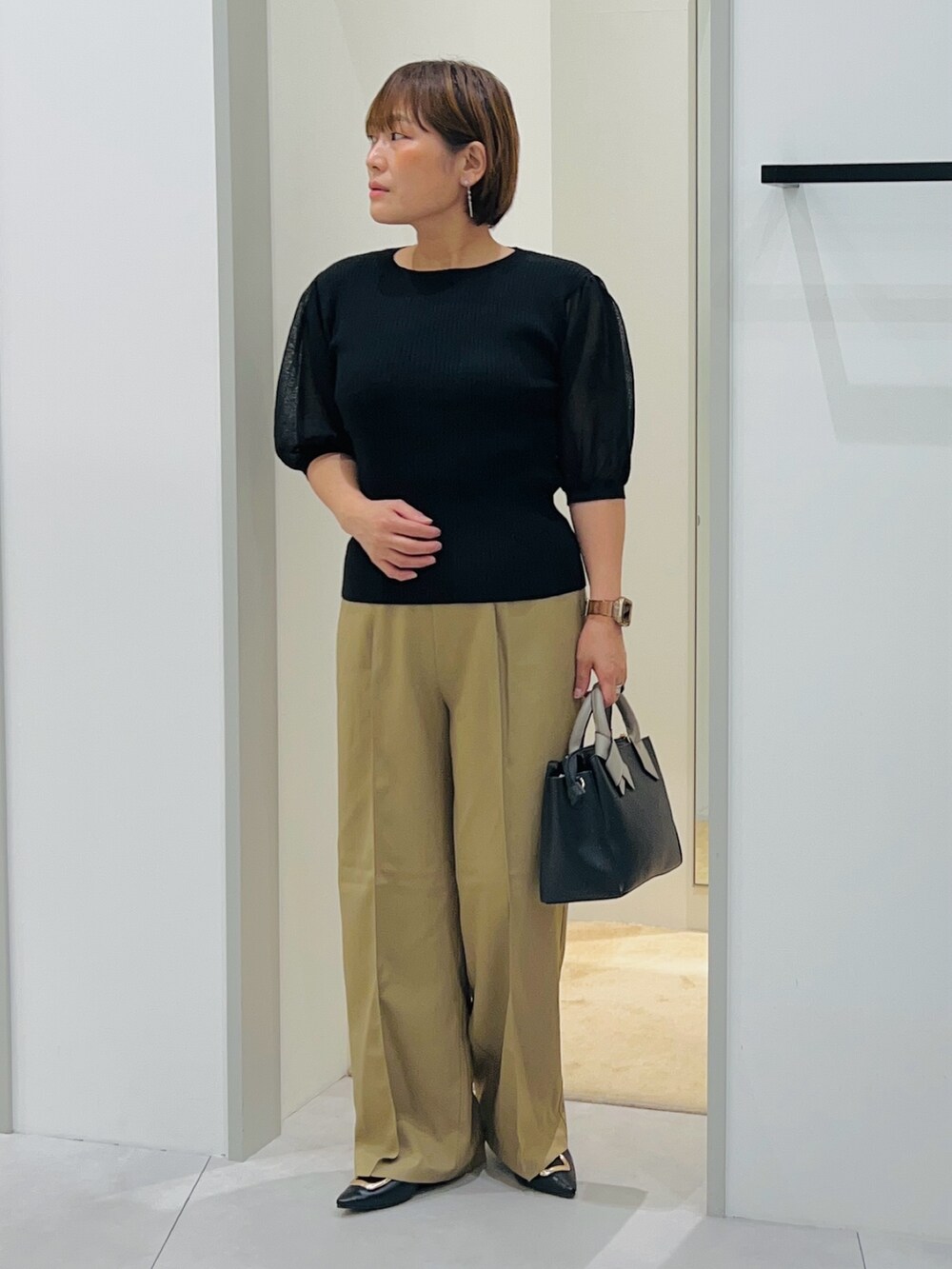 ブラック系のニット/セーター、ベージュ系のその他パンツ、ブラック系のショルダーバッグを着用したレディースの秋コーディネートの4枚目の写真