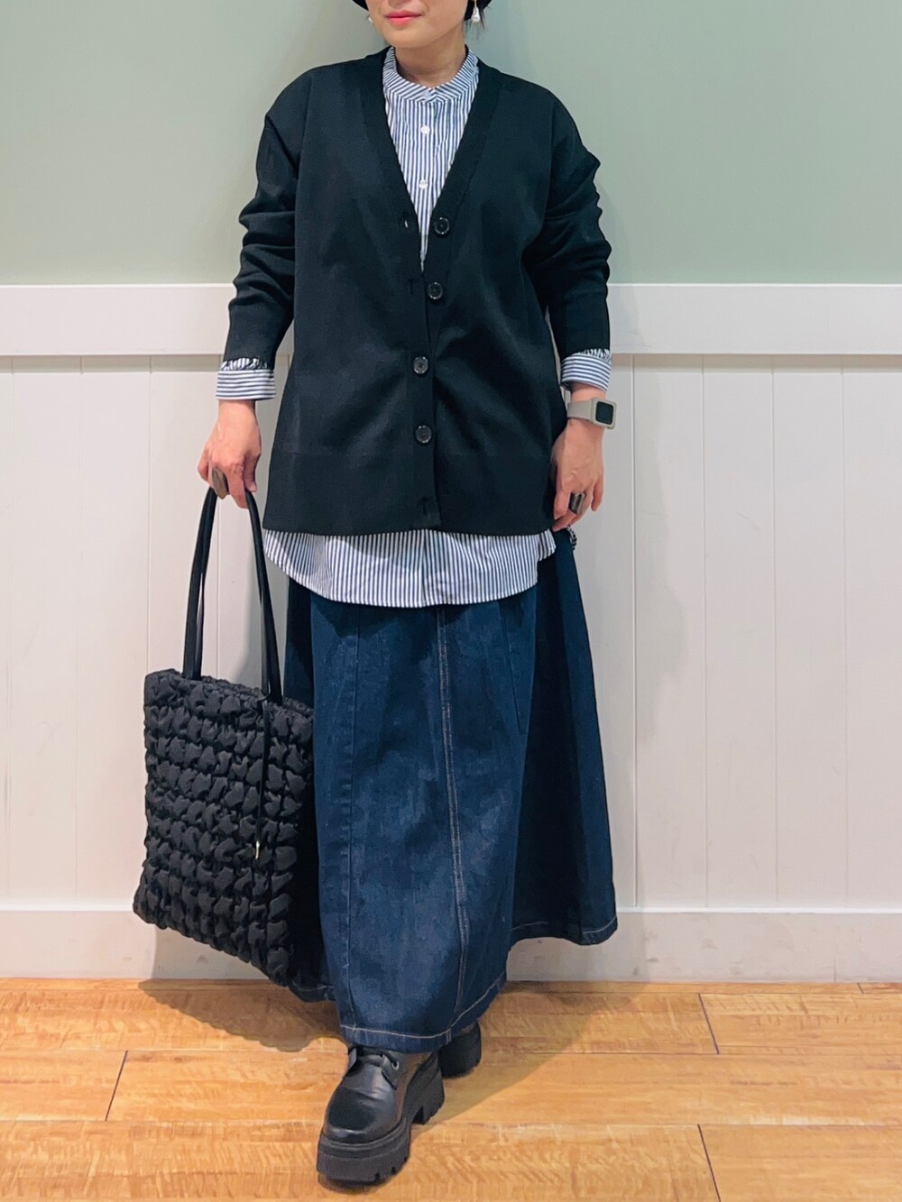 ブラック系のカーディガン/ボレロ、ブルー系のシャツ/ブラウス、ブルー系のデニムスカートを着用したレディースの秋コーディネートの3枚目の写真