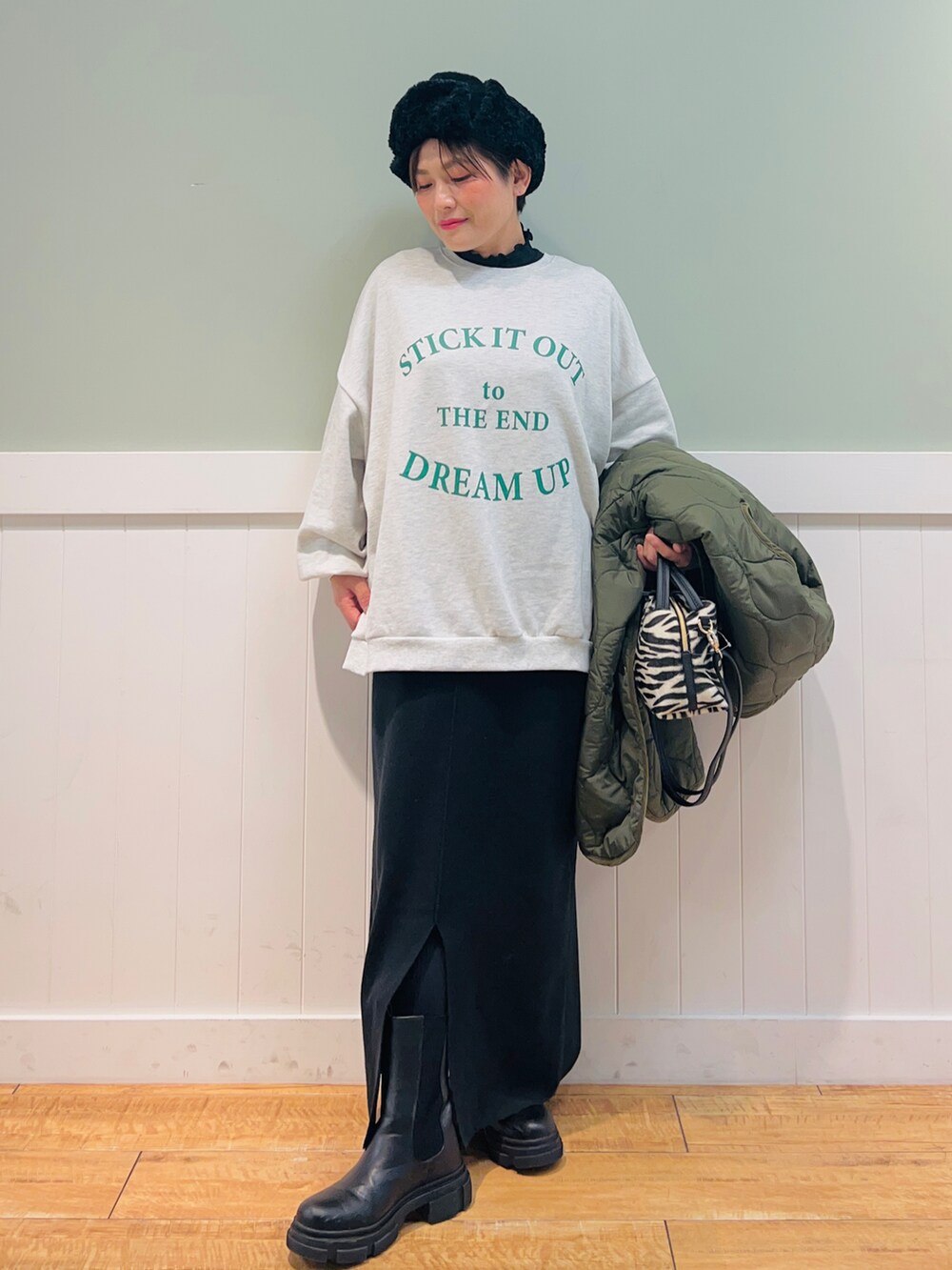 グリーン系のノーカラーコート、グレー系のスウェット、ブラック系のショルダーバッグを着用したレディースの秋コーディネートの4枚目の写真