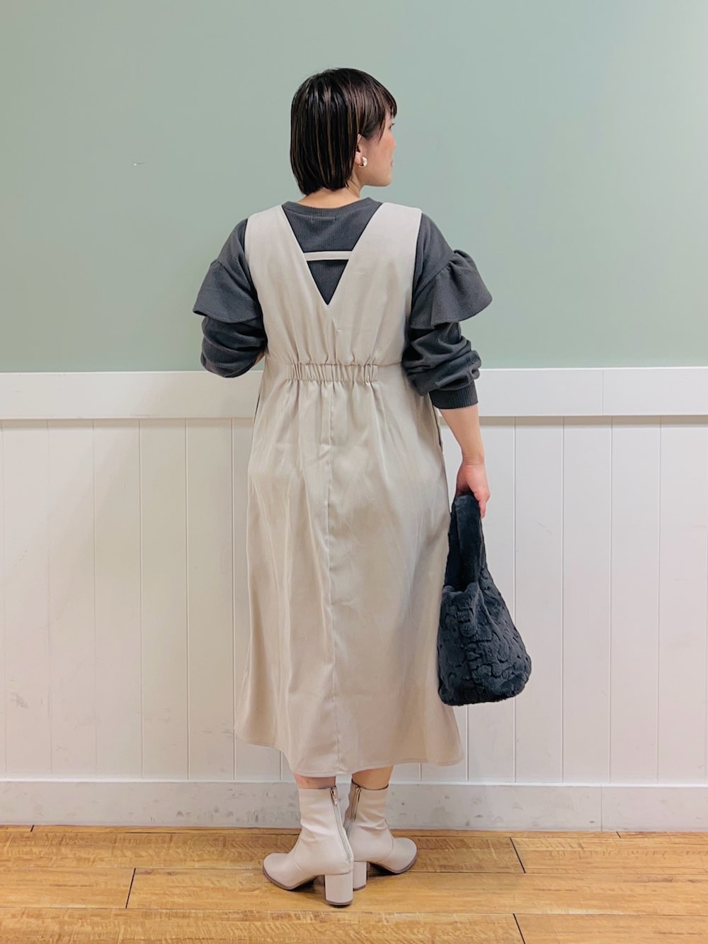 ベージュ系のワンピース、グレー系のTシャツ/カットソー、グレー系のトートバッグを着用したレディースの冬コーディネートの4枚目の写真