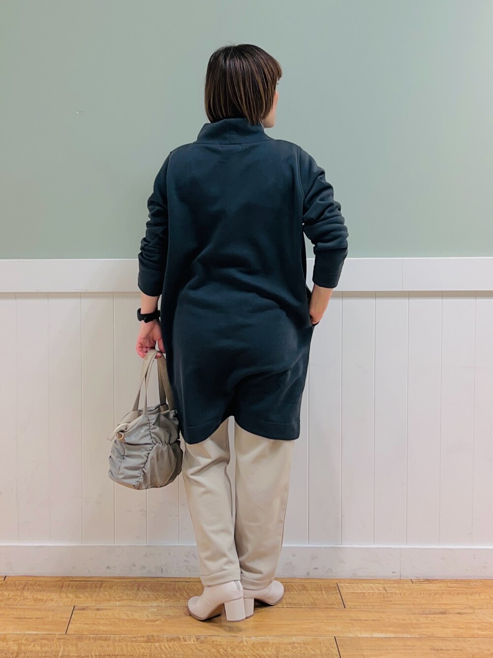 グレー系のチュニック、ブラウン系のトートバッグ、ベージュ系のその他パンツを着用したレディースの冬コーディネートの3枚目の写真