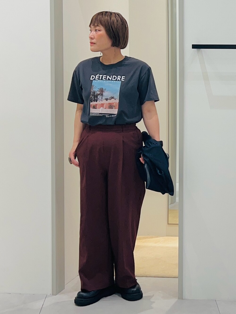 ブルー系のベスト、ブラック系のパンプス、ブラウン系のその他パンツを着用したレディースの春コーディネートの2枚目の写真