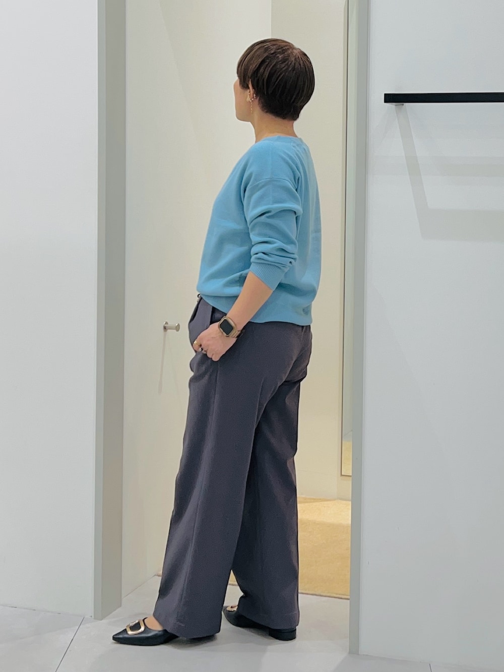 ブルー系のニット/セーター、ブラック系のショルダーバッグ、ブラック系のパンプスを着用したレディースの秋コーディネートの3枚目の写真