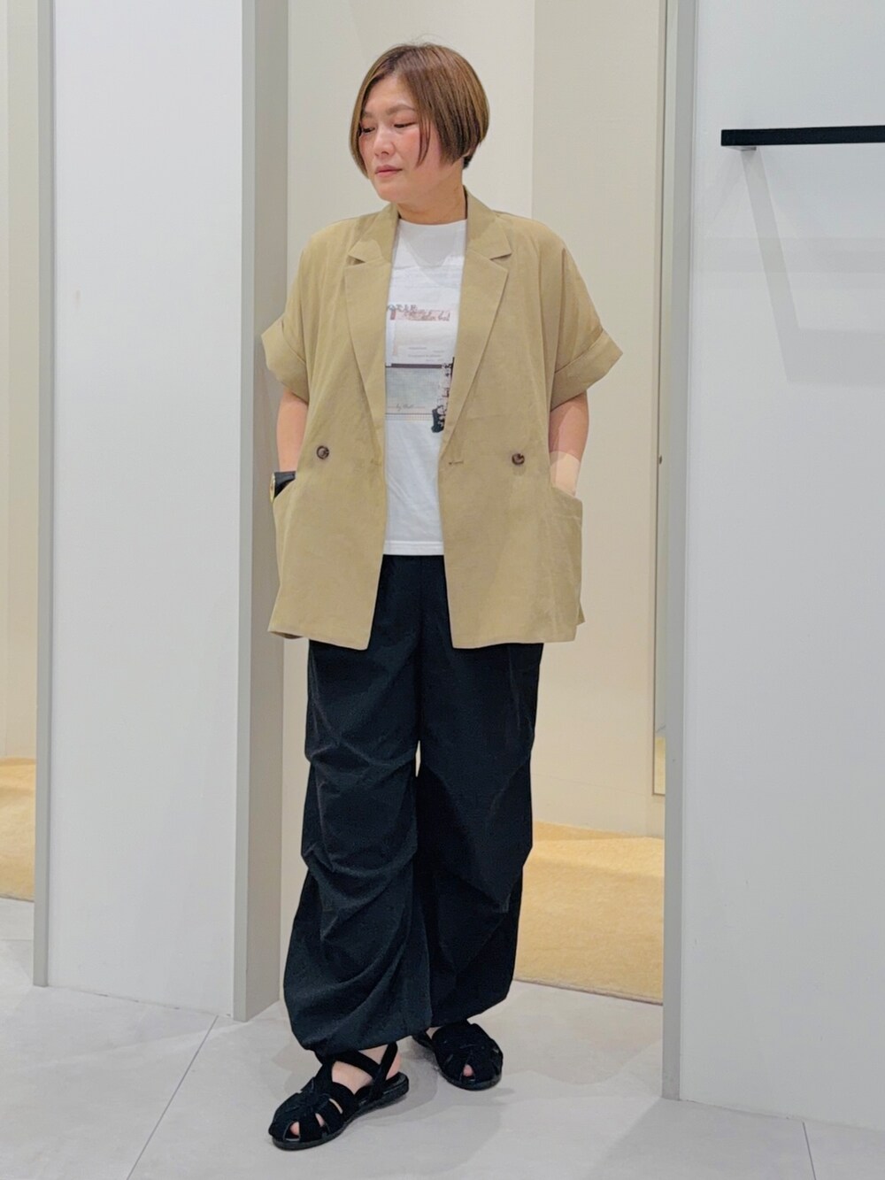 ベージュ系のテーラードジャケット、ベージュ系のTシャツ/カットソー、ブラック系のその他パンツを着用したレディースの夏コーディネートの2枚目の写真