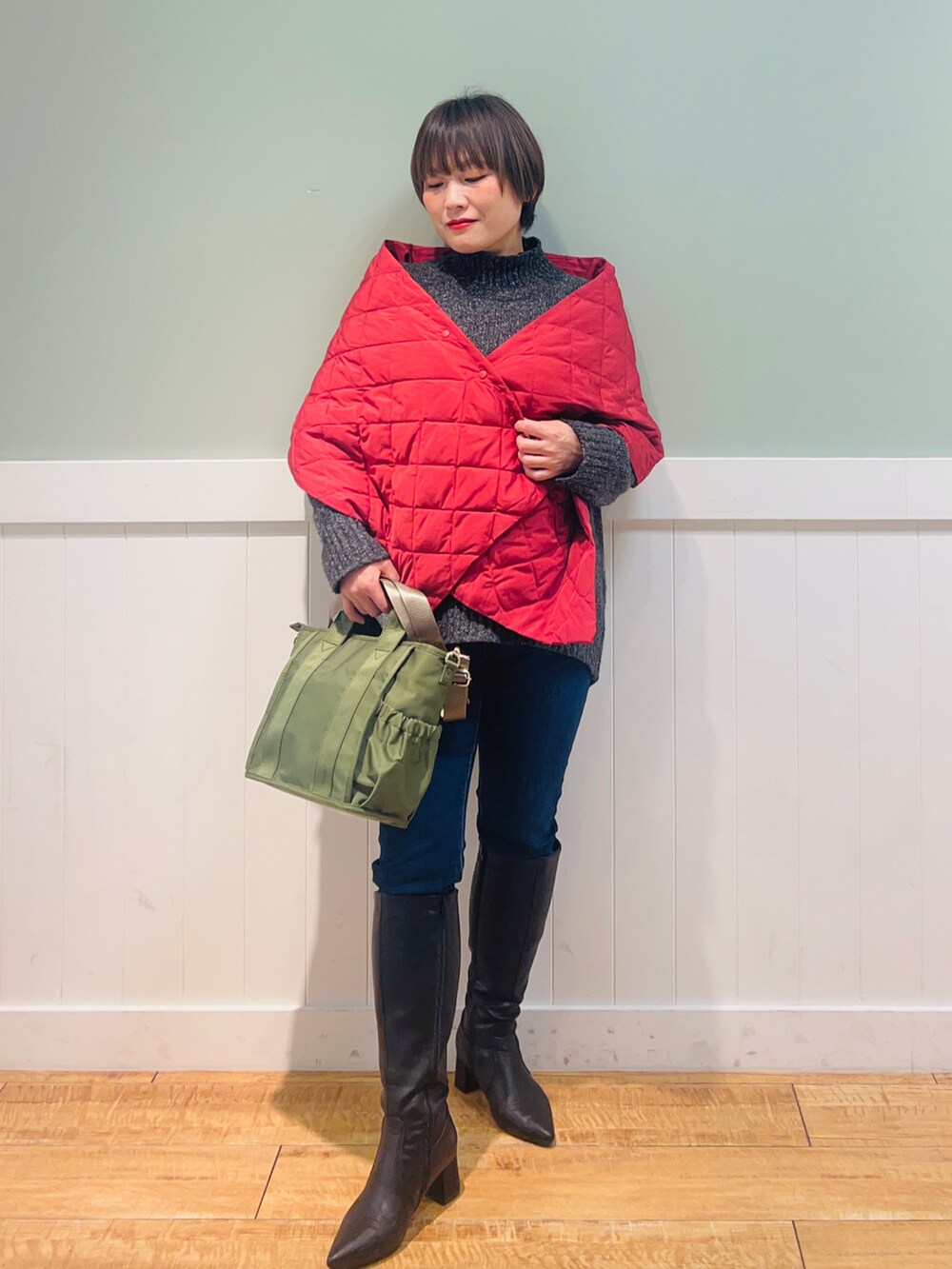 グレー系のニット/セーター、ブルー系のデニムパンツ、グリーン系のトートバッグを着用したレディースの冬コーディネートの5枚目の写真