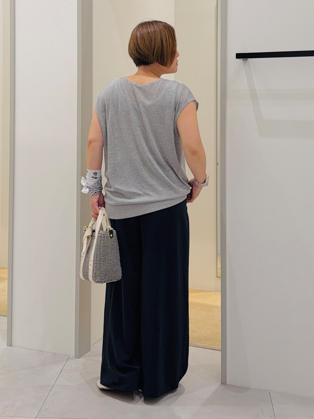 グレー系のニット/セーター、ブルー系のその他パンツ、グレー系のハンドバッグを着用したレディースの夏コーディネートの4枚目の写真