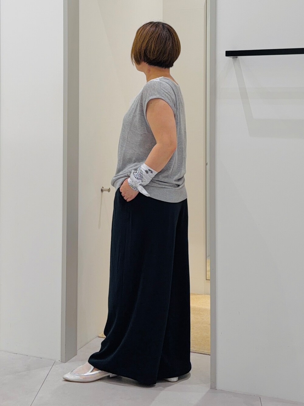 グレー系のニット/セーター、ブルー系のその他パンツ、グレー系のハンドバッグを着用したレディースの夏コーディネートの3枚目の写真