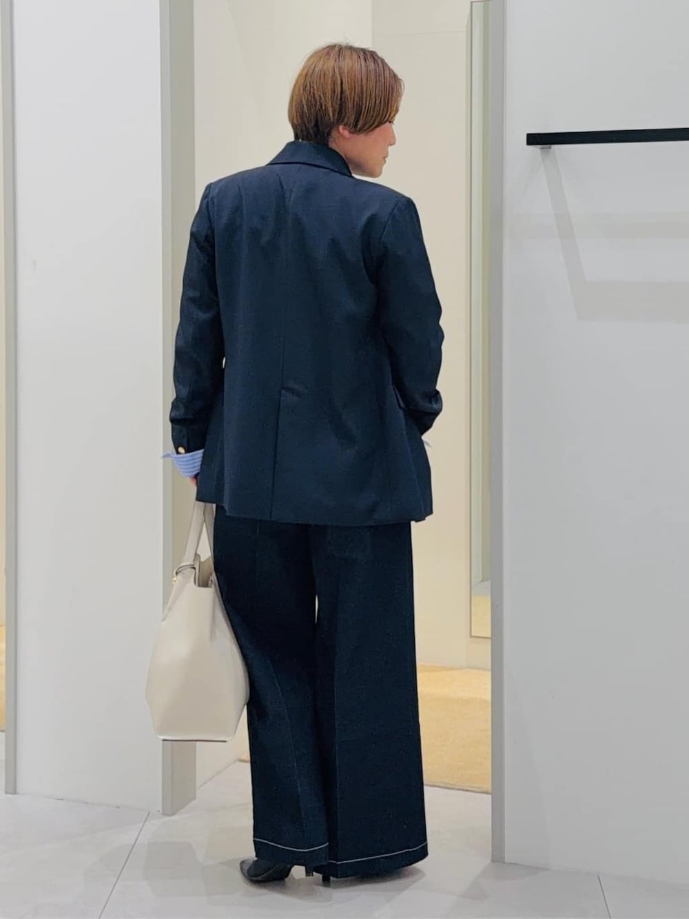 ブルー系のデニムパンツ、ホワイト系のTシャツ/カットソー、ホワイト系のトートバッグを着用したレディースの春コーディネートの3枚目の写真
