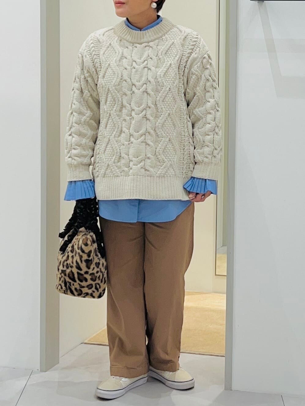 ホワイト系のニット/セーター、ブルー系のシャツ/ブラウス、ベージュ系のその他パンツを着用したレディースの冬コーディネートの4枚目の写真