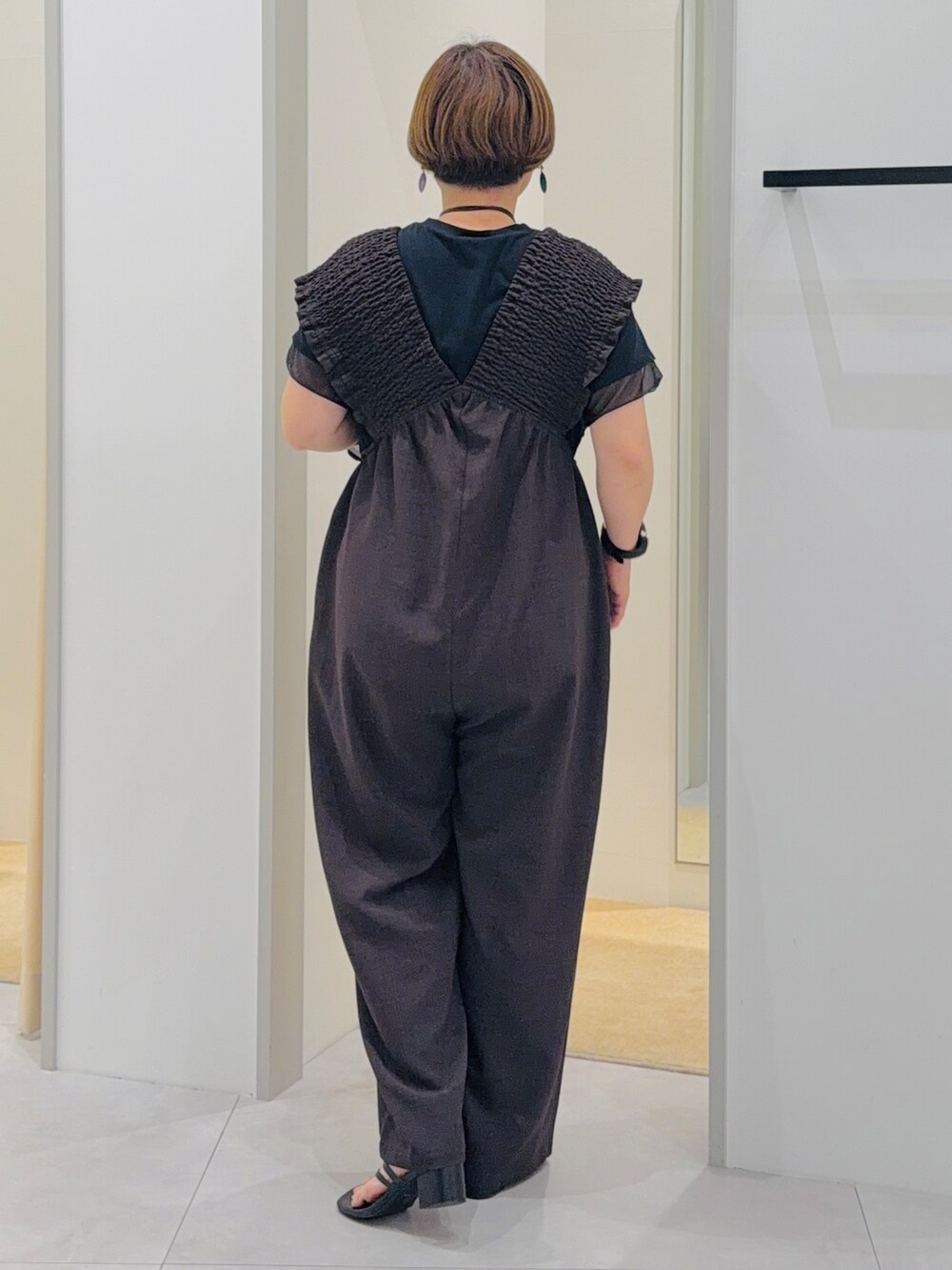 ブラウン系のサロペット/オーバーオール、ブラック系のTシャツ/カットソー、ブルー系のバンダナ/スカーフを着用したレディースの夏コーディネートの3枚目の写真