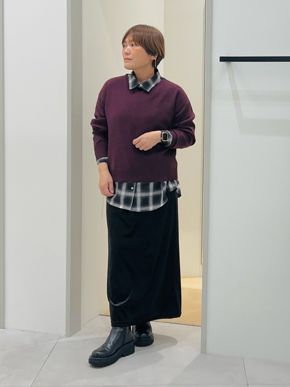 ブラック系のシャツ/ブラウス、ブラック系のスカート、ブラック系のブーツを着用したレディースの秋コーディネートの3枚目の写真