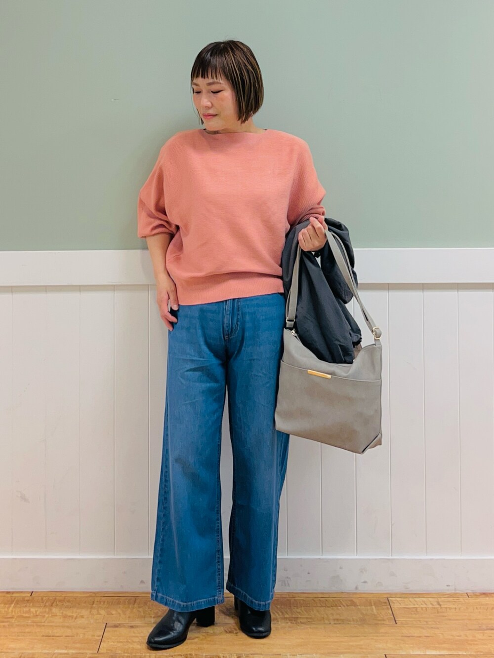 グレー系のブルゾン、ピンク系のニット/セーター、グレー系のショルダーバッグを着用したレディースの秋コーディネートの2枚目の写真