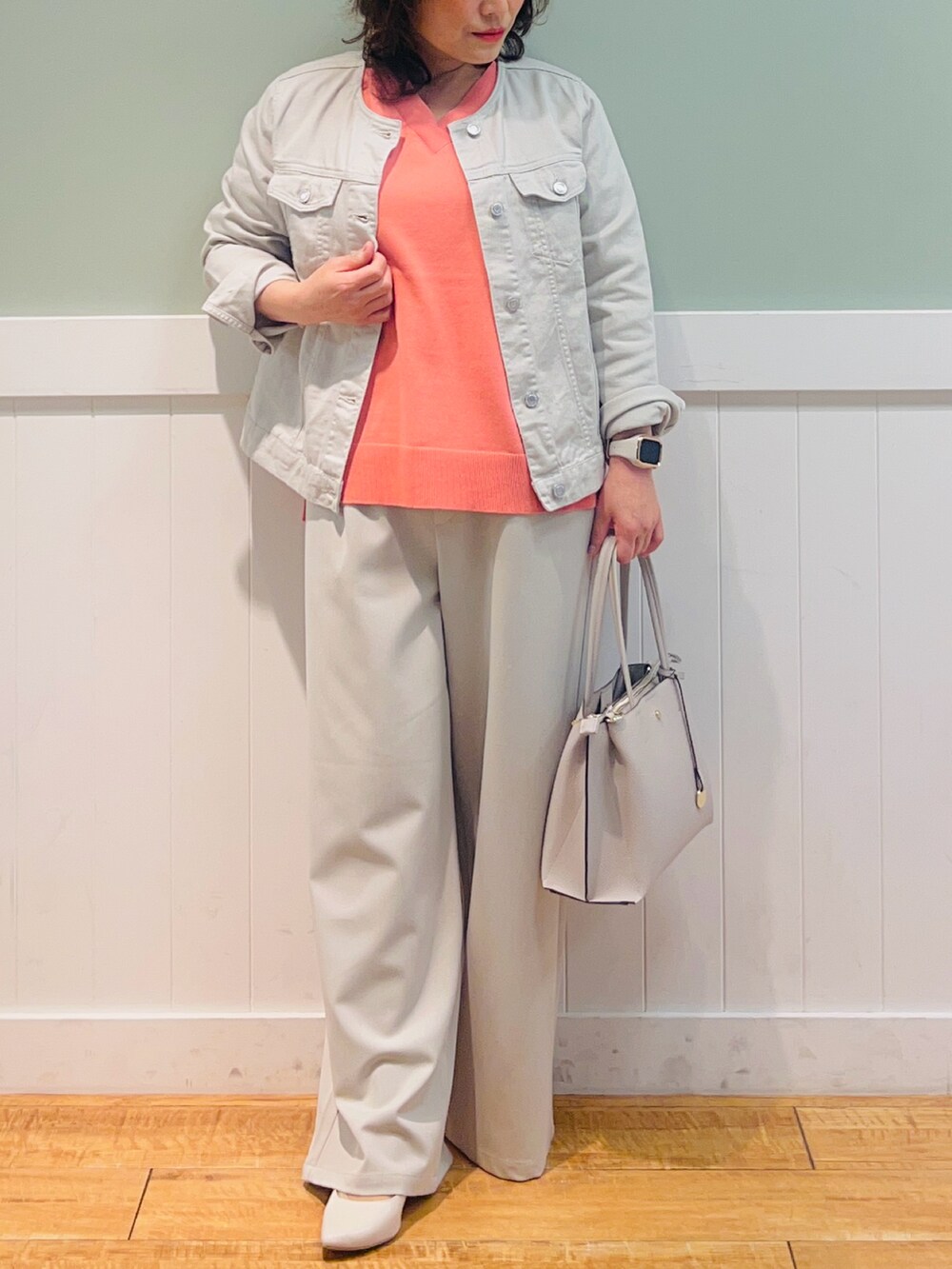 グレー系のデニムジャケット、ピンク系のニット/セーター、グレー系のトートバッグを着用したレディースの春コーディネートの4枚目の写真