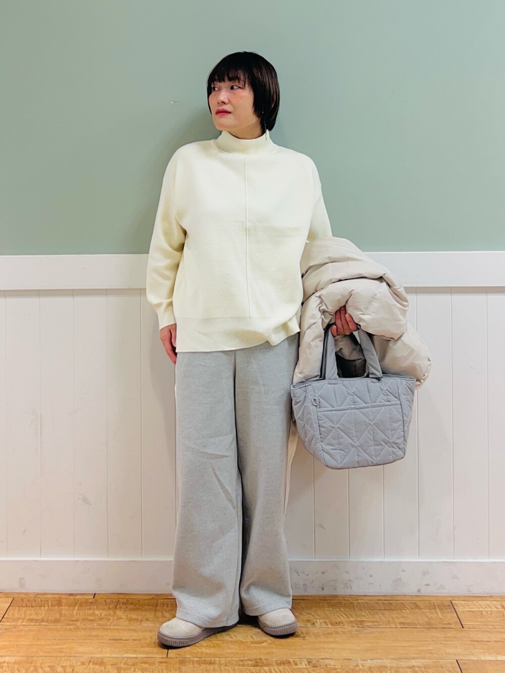 ベージュ系のダウンジャケット/コート、ホワイト系のニット/セーター、グレー系のその他パンツを着用したレディースの冬コーディネートの2枚目の写真