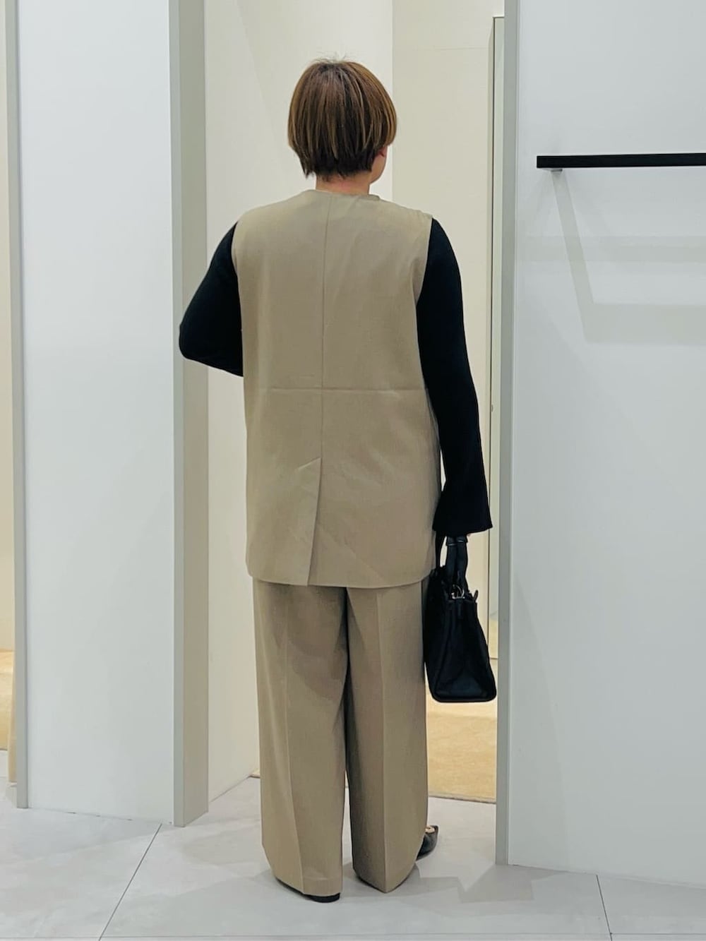 ベージュ系のベスト、ブラック系のニット/セーター、ベージュ系のその他パンツを着用したレディースの冬コーディネートの4枚目の写真