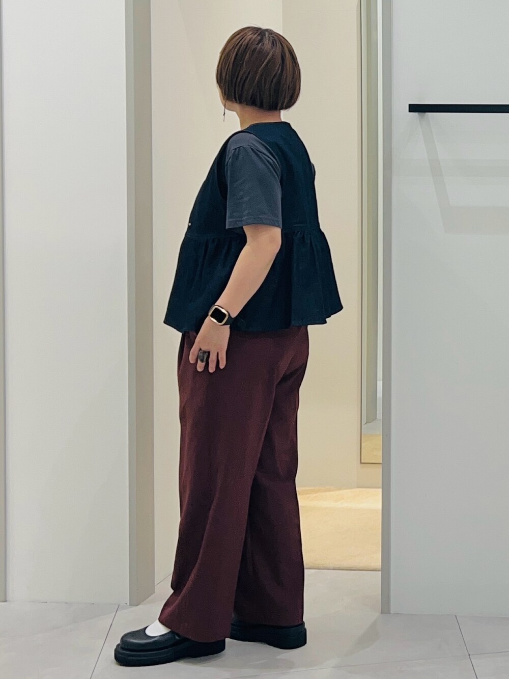 ブルー系のベスト、ブラック系のパンプス、ブラウン系のその他パンツを着用したレディースの春コーディネートの3枚目の写真