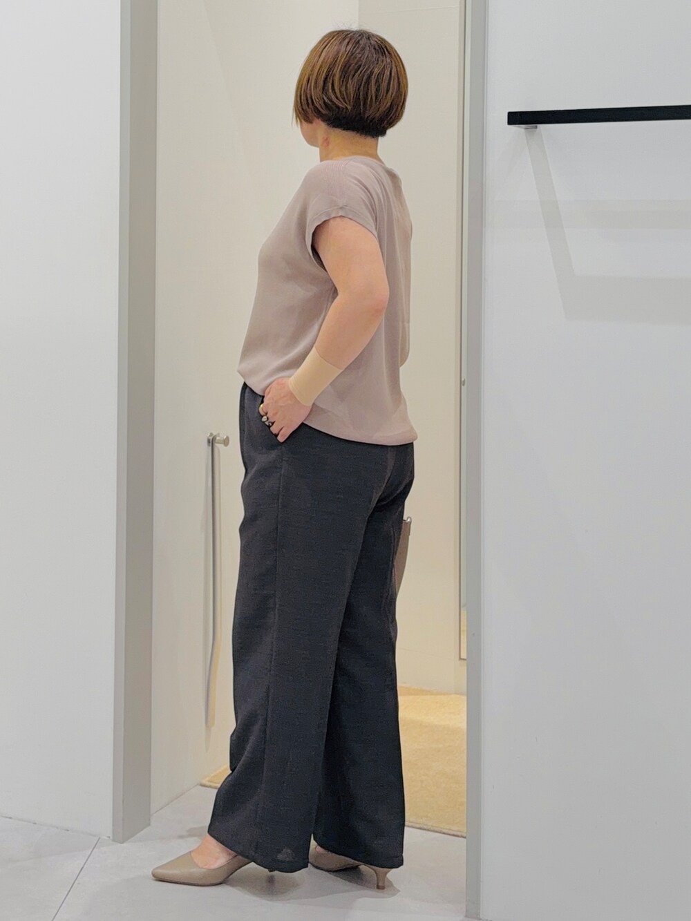 ベージュ系のニット/セーター、ブラック系のその他パンツ、ブラウン系のトートバッグを着用したレディースの夏コーディネートの3枚目の写真