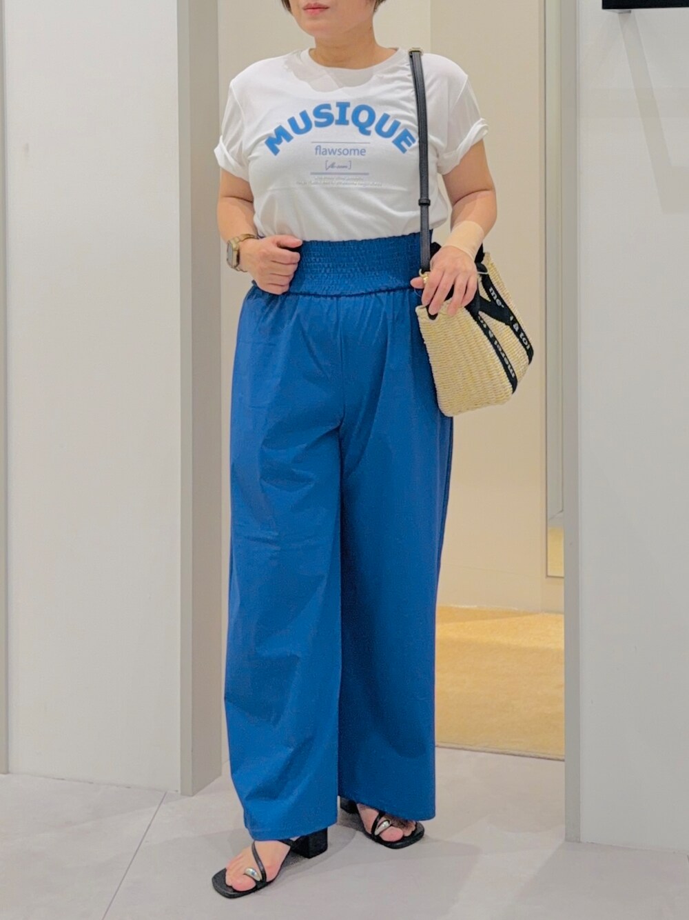 ホワイト系のTシャツ/カットソー、ブルー系のその他パンツ、ベージュ系のハンドバッグを着用したレディースの夏コーディネートの5枚目の写真
