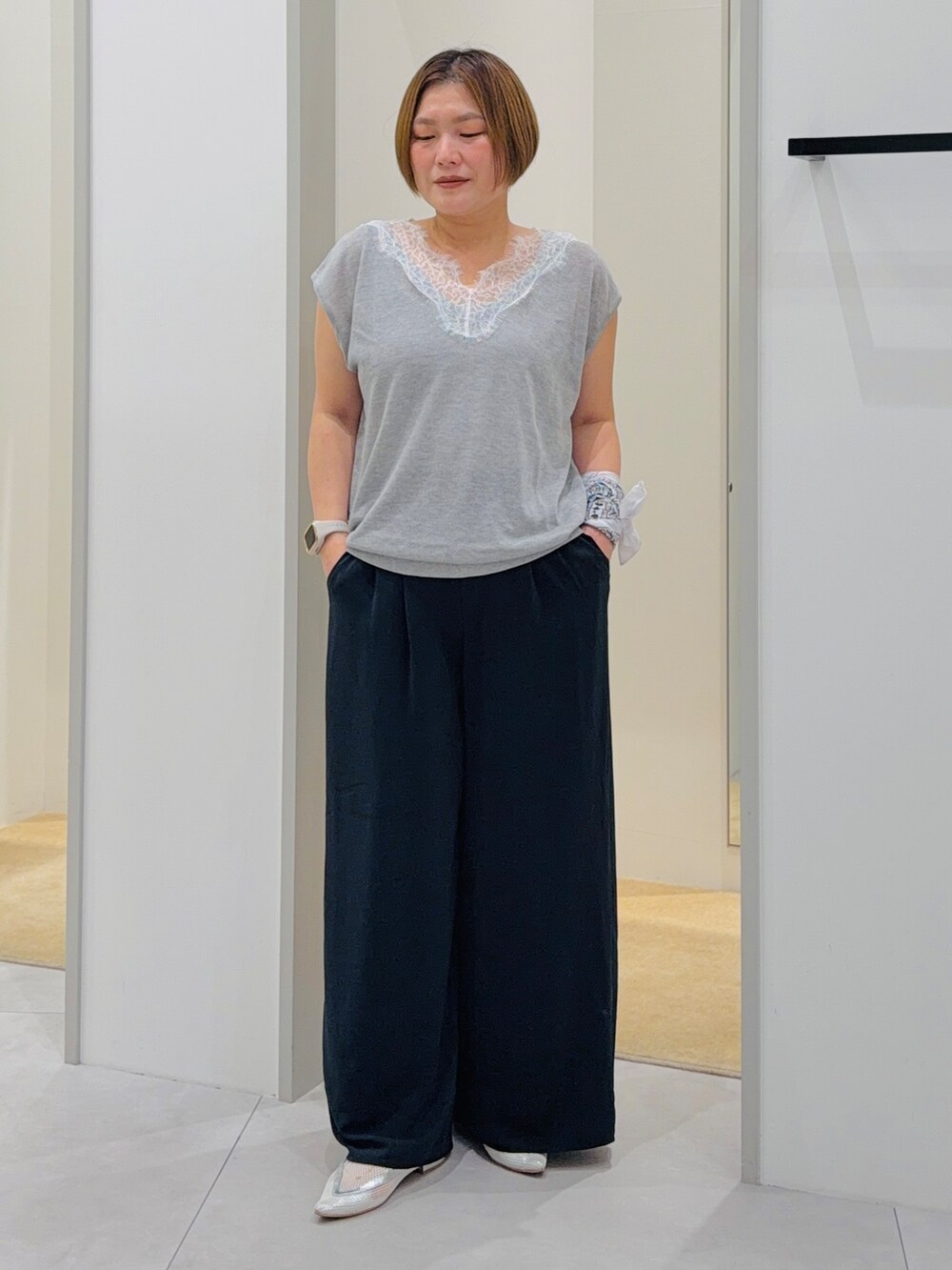 グレー系のニット/セーター、ブルー系のその他パンツ、グレー系のハンドバッグを着用したレディースの夏コーディネートの2枚目の写真