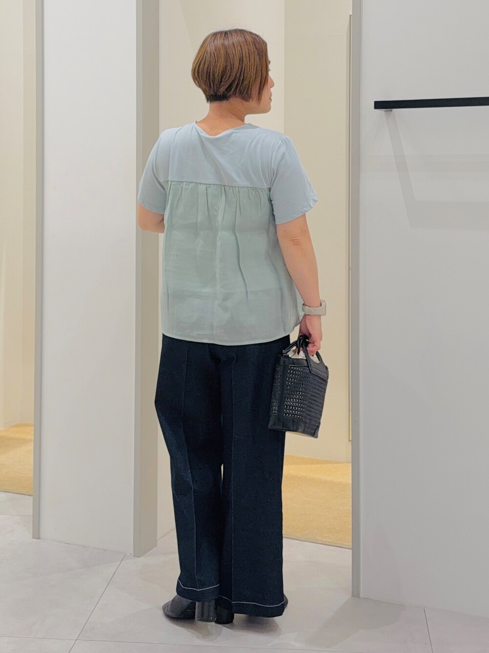 グリーン系のTシャツ/カットソー、ブラック系のデニムパンツ、グリーン系のショルダーバッグを着用したレディースの夏コーディネートの4枚目の写真