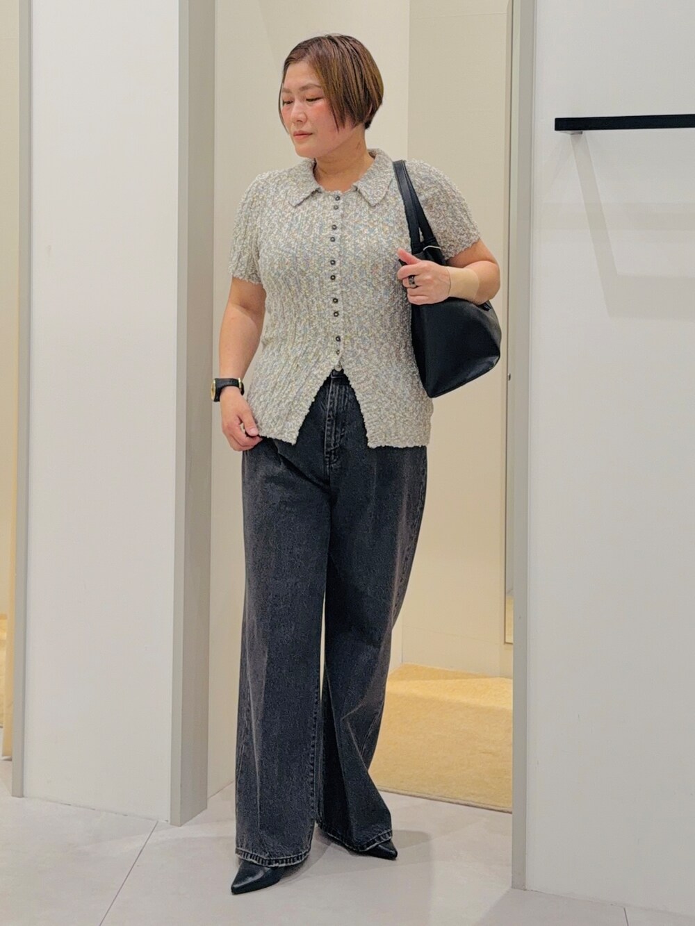 グレー系のニット/セーター、ブラック系のデニムパンツ、ブラック系のトートバッグを着用したレディースの夏コーディネートの2枚目の写真