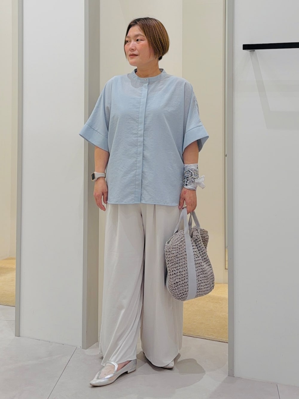 ブルー系のシャツ/ブラウス、ホワイト系のその他パンツ、グレー系のトートバッグを着用したレディースの夏コーディネートの2枚目の写真