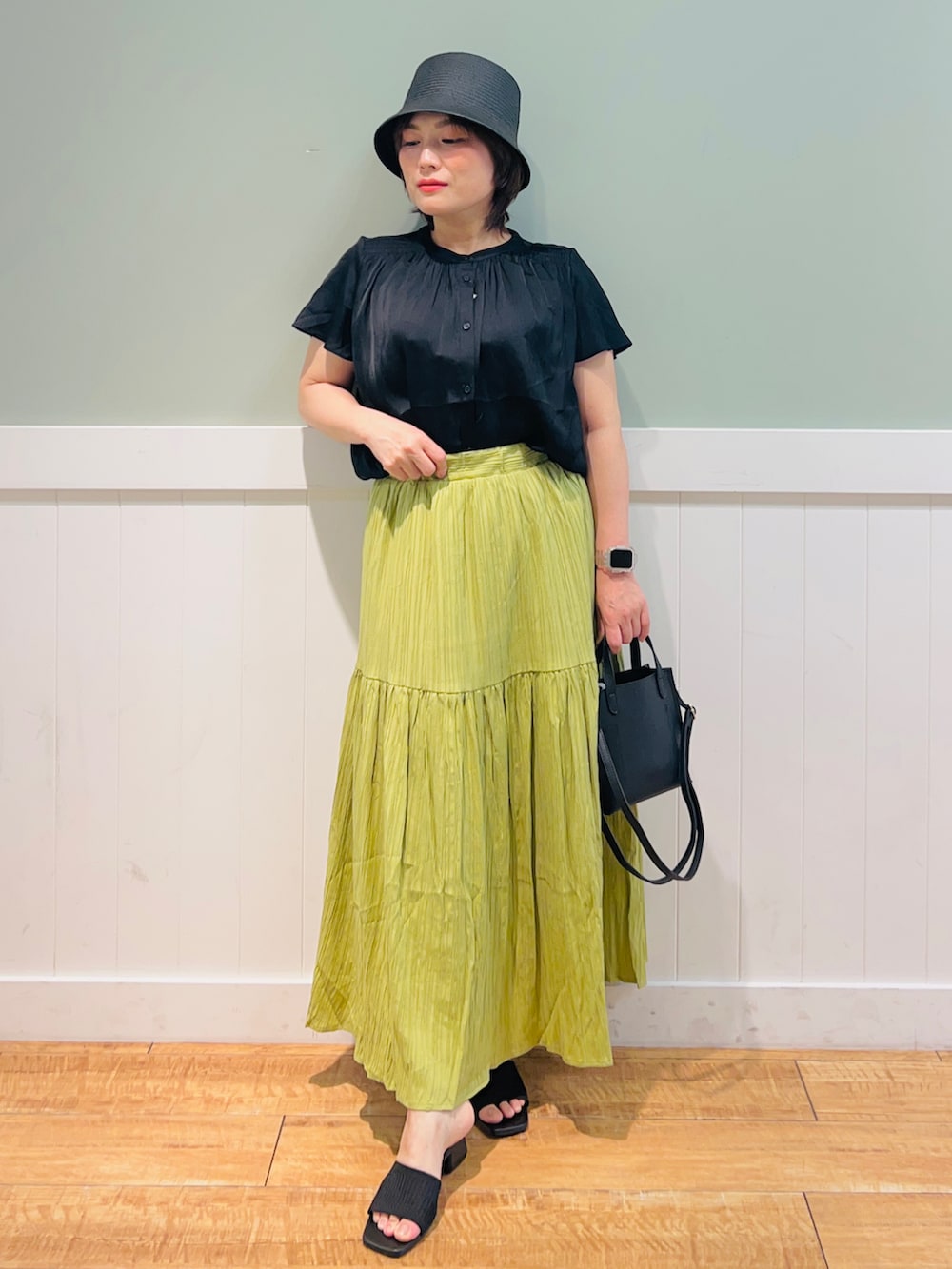 ブラック系のシャツ/ブラウス、ブラック系のショルダーバッグ、グリーン系のスカートを着用したレディースの春コーディネートの3枚目の写真