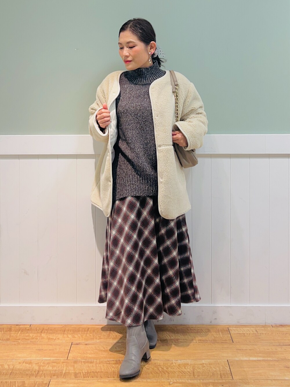 ブラウン系のニット/セーター、ホワイト系のブルゾン、ブラウン系のスカートを着用したレディースの冬コーディネートの4枚目の写真