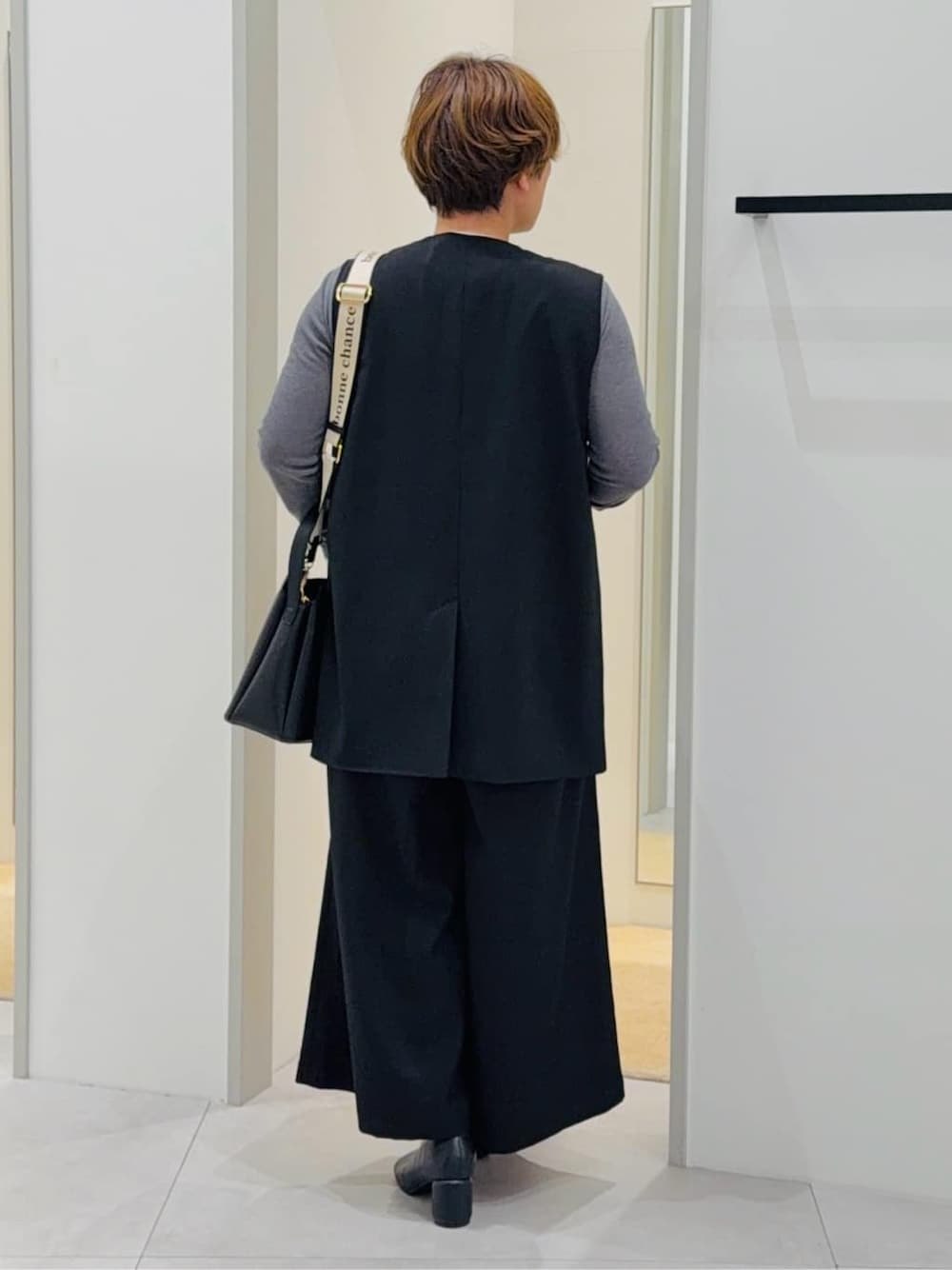 ブラック系のベスト、ブラック系のサロペット/オーバーオール、グレー系のTシャツ/カットソーを着用したレディースの春コーディネートの3枚目の写真