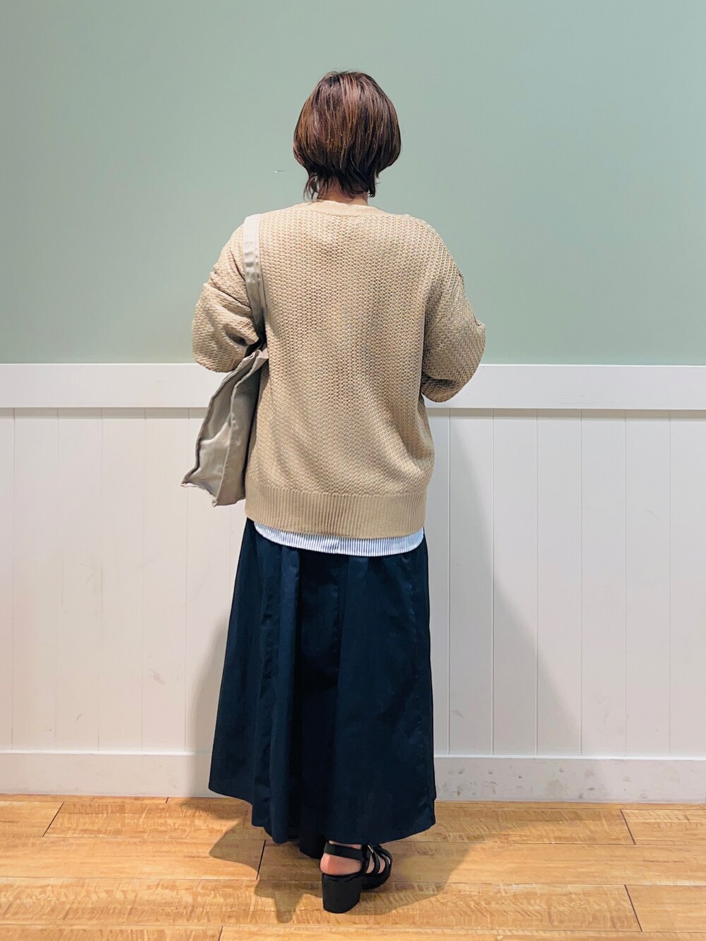 ブルー系のシャツ/ブラウス、ベージュ系のカーディガン/ボレロ、グレー系のトートバッグを着用したレディースの春コーディネートの2枚目の写真