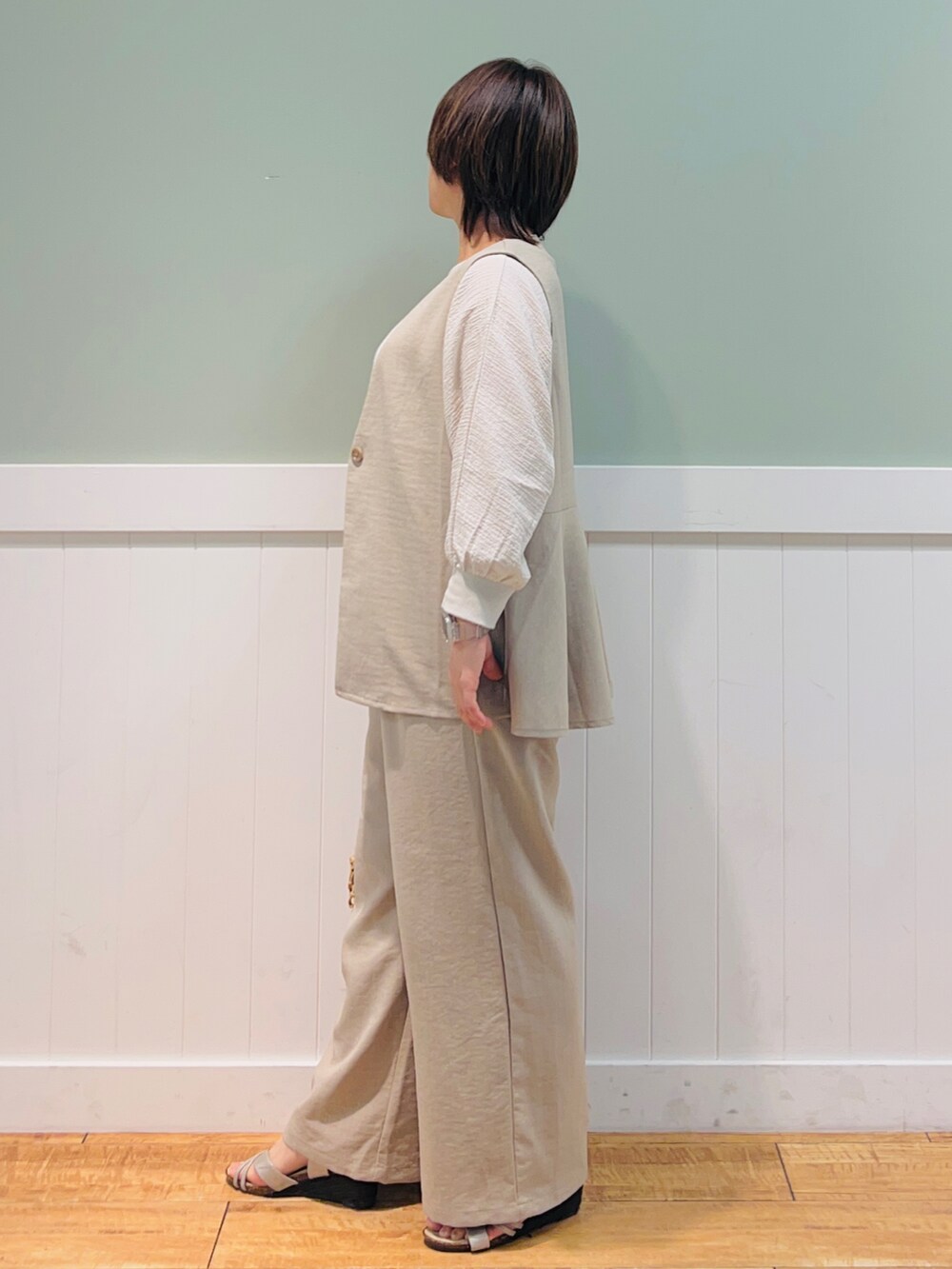 ベージュ系のベスト、ブラウン系のトートバッグ、ベージュ系のシャツ/ブラウスを着用したレディースの春コーディネートの3枚目の写真