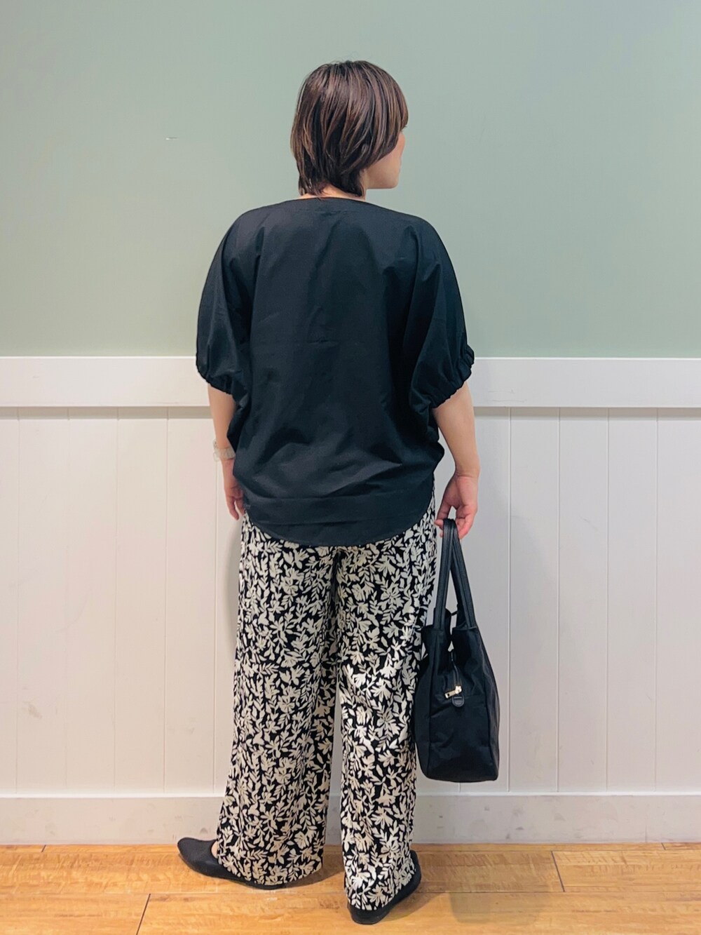 ブラック系のTシャツ/カットソー、ブラック系のその他パンツ、ブラック系のトートバッグを着用したレディースの春コーディネートの2枚目の写真