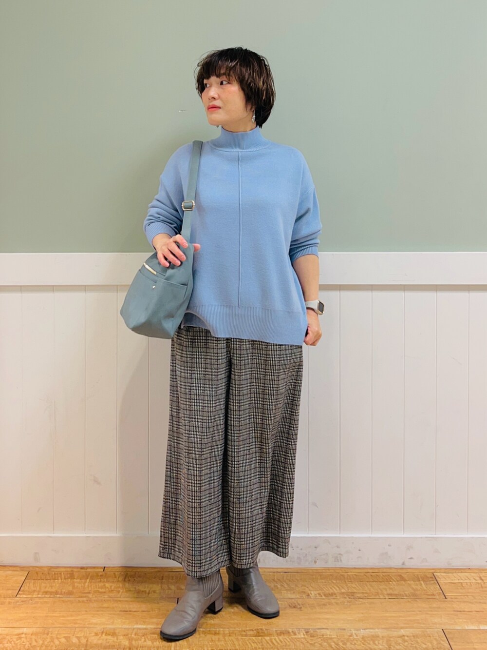 ブルー系のニット/セーター、ベージュ系のその他パンツ、ブルー系のショルダーバッグを着用したレディースの冬コーディネートの2枚目の写真