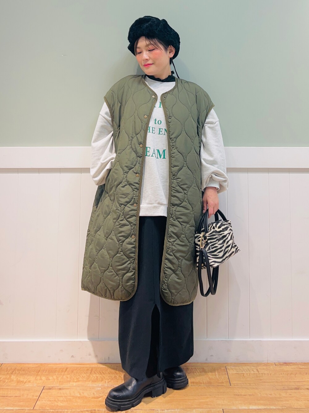 グリーン系のノーカラーコート、グレー系のスウェット、ブラック系のショルダーバッグを着用したレディースの秋コーディネートの5枚目の写真