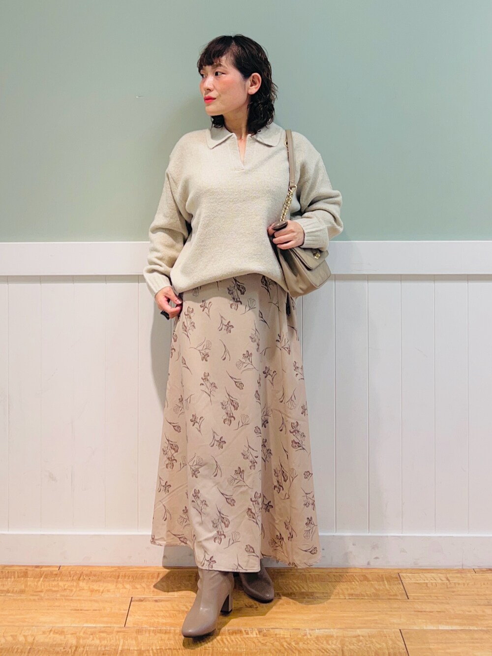 ベージュ系のニット/セーター、ベージュ系のショルダーバッグ、ベージュ系のスカートを着用したレディースの冬コーディネートの2枚目の写真